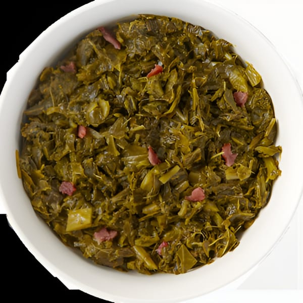 A white bowl filled with dark green collard greens and small pieces of red meat.